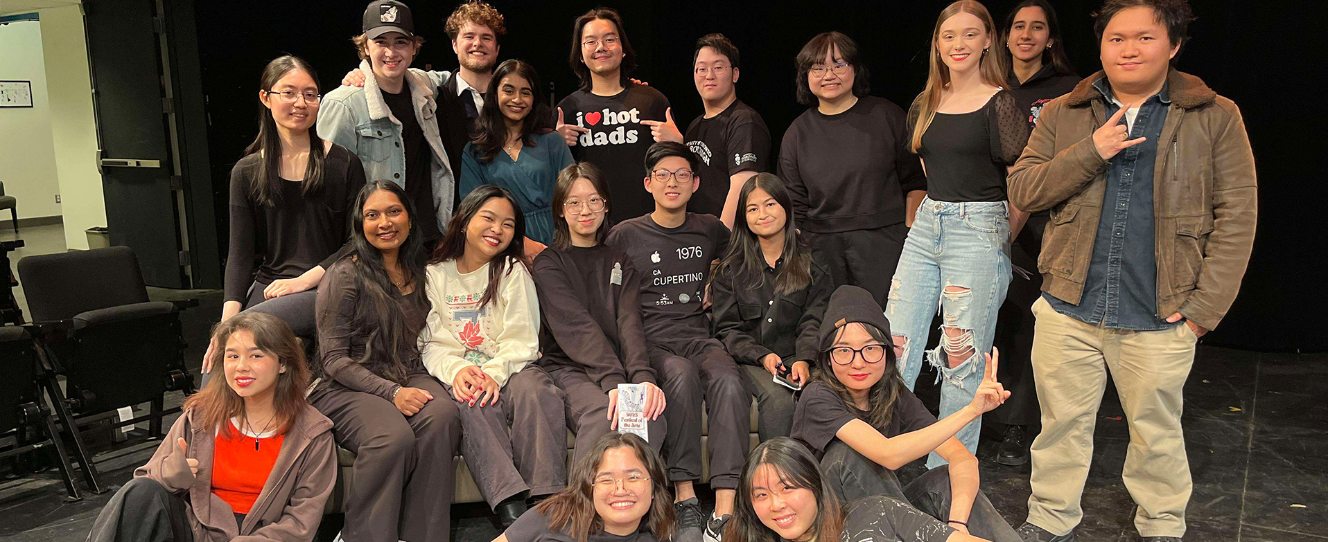 A crowd of students in the theatre face the camera