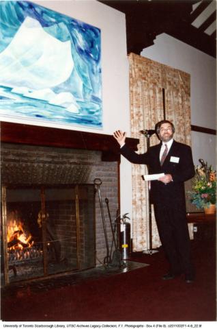 Principal Paul Thompson in front of Doris McCarthy painting over the fireplace at Miller Lash house