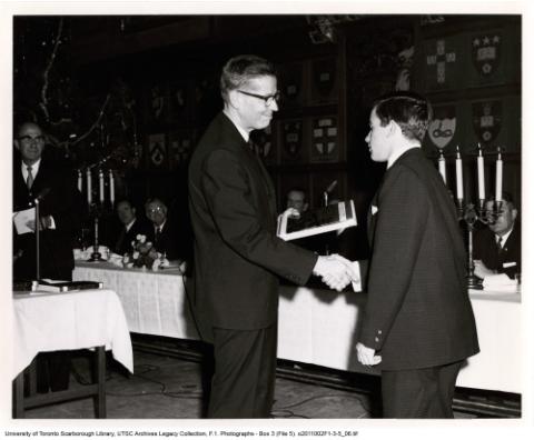 Student shaking man's hand at an award ceremony banquet