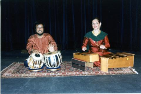 Two students playing the tabla and wooden xylophone