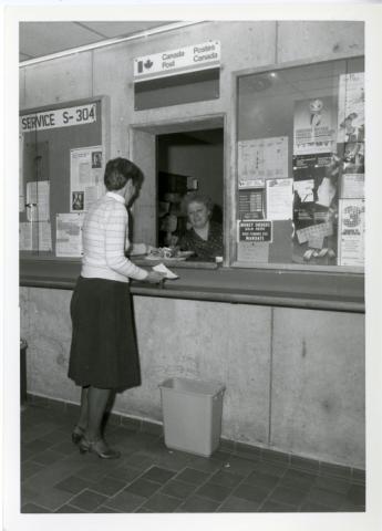 Photograph of woman mailing a package at Canada Post kiosk
