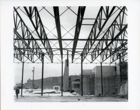 Construction of original Andrews building, view of smoke stacks, steel scaffolding, and construction workers