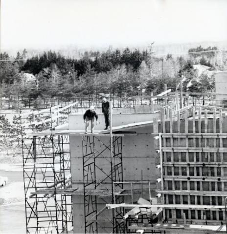 Construction of original Andrews building, view of two workers on scaffold