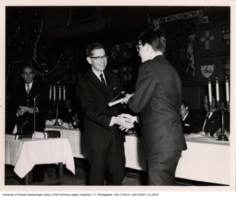 Student shaking man's hand at an award ceremony banquet