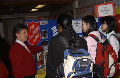 Students Speak with Presenter at the Salvation Army Table, Volunteer Fair, the Meeting Place