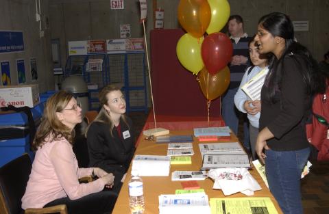 Students Speak with Presenters at Table, Volunteer Fair, the Meeting Place