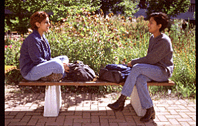 Two Students, Seated on Bench, Outdoors, H-Wing Patio