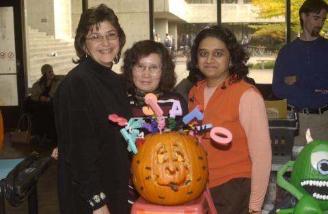 People Pose for Photograph with Pumpkin Carving Contest Entry. the Meeting Place