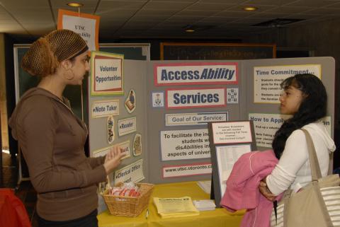 Student Speaks with Presenter at AccessAbility Table, Expand Your Horizons: Volunteer & Internship Fair, the Meeting Place