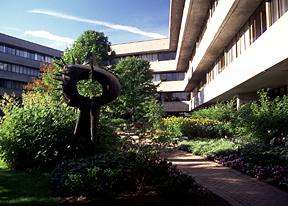 View of Louis Archambault's sculpture, A Tall Couple, 1966, H-Wing and H-Wing Patio in Background