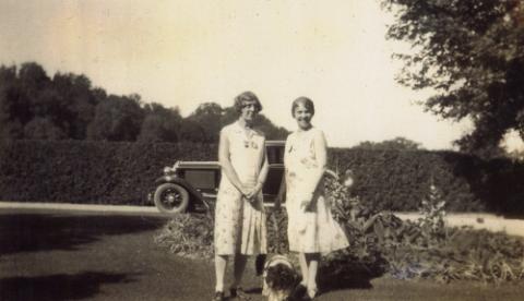 Two Women with Dog Standing by Garden, Miller Lash House Property, Car in Background