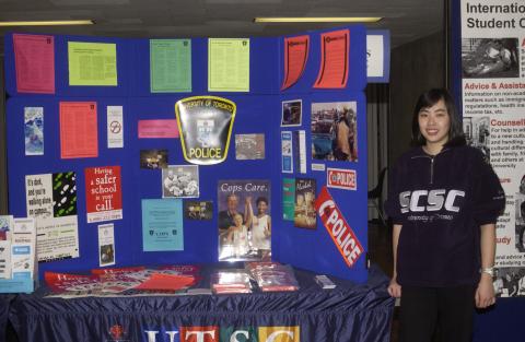 Student Stands beside Campus Police Display, Graditude 0T2 Week Event in the Meeting Place