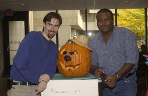 Two Men Pose for Photograph with Pumpkin Carving Contest Entries, the Meeting Place