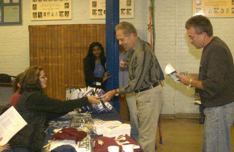 Spectators Registering and Picking up Penants at Registration Table, Homecoming Event, (Varsity Arena, St. George Campus?)