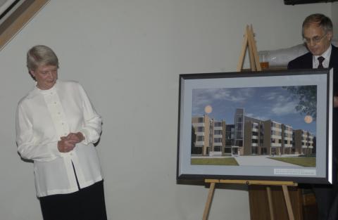 Joan Foley Standing by Commemorative Print of Joan Foley Hall, Joan Foley Hall Residence, Opening Event