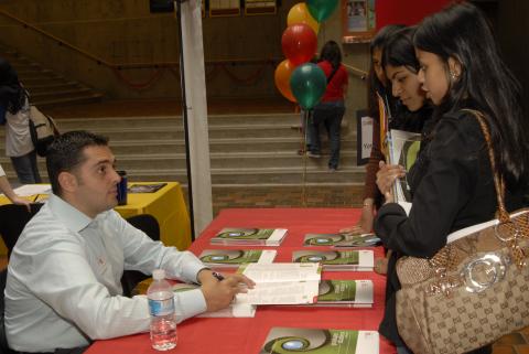 Student Speaks with Representative at Table, Graduate and Professional Schools Fair, the Meeting Place