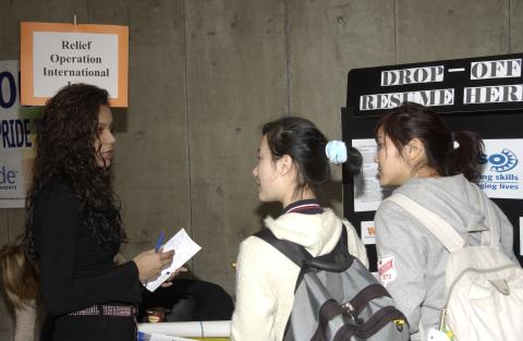 Presenter Speaks with Students at Table, Relief Operation International Inc., Volunteer Fair, the Meeting Place
