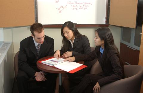 Management Co-op Students, Posed Scene at Table with Whiteboard, Promotional Image