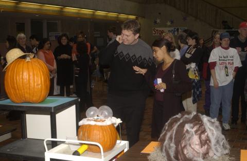 People Look at Pumpkin Carving Contest Entries, the Meeting Place