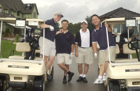 Four Players Pose with Golf Carts near Club Buildings, Management Alumni Association Golf Tournament, 2002, Deer Creek Golf Club