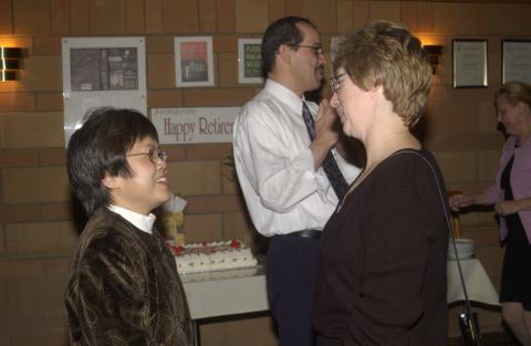 Event Attendee Talks with Loan Le, Robert Campbell in Background, Retirement Celebration for Pat Yakimov and Loan Le, Faculty Dining Room