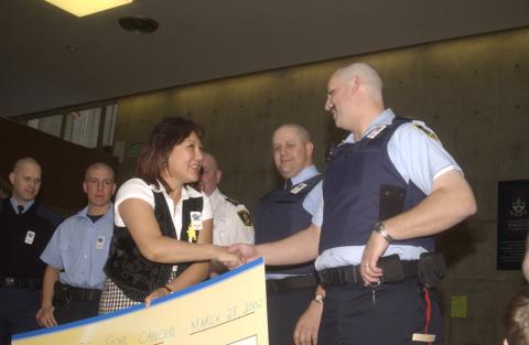 Representative of Canadian Cancer Society with Campus Police Officers and Novelty Cheque, Cops for Cancer Event, the Meeting Place