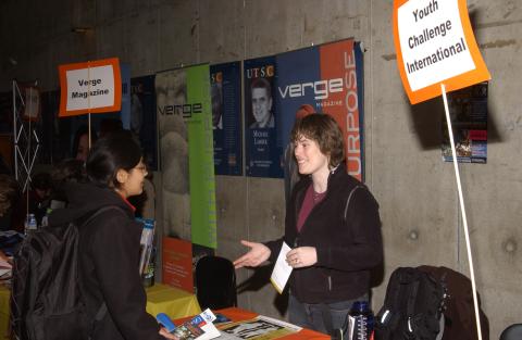 Student Speaks with Presenter at Youth Challenge International Table, Volunteer Fair, the Meeting Place