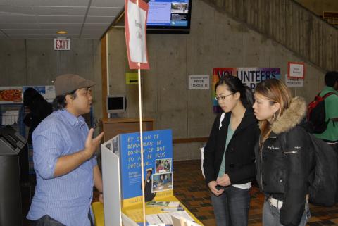 Presenter Talks to Students at Frontier College Table, Expand Your Horizons: Volunteer & Internship Fair, the Meeting Place