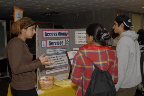 Presenter Talks to Students at AccessAbility Services Table, Expand Your Horizons: Volunteer & Internship Fair, the Meeting Place