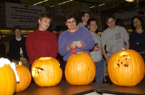 Judge Looks at Entry, Pumpkin Carving Contest, the Meeting Place