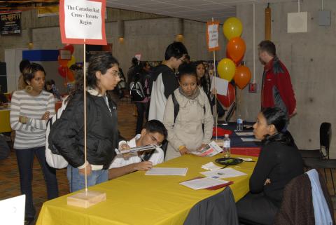 Students Look at Material, Sign Document and Speak with Presenter at The Canadian Red Cross, Toronto Region Table, Expand Your Horizons: Volunteer & Internship Fair, the Meeting Place