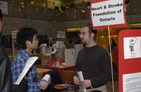 Student talks with Presenter, Heart and Stroke Foundation of Canada Table, Volunteer Fair, the Meeting Place