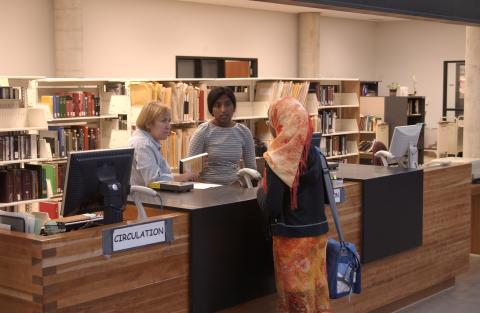 Beverley Nicholson with Student Library Assistant and Student, Circulation Desk, Library