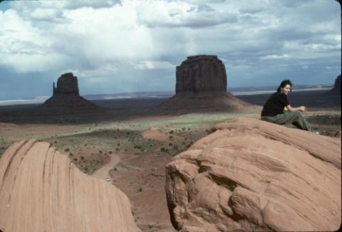 Student Seated on Rock, Monument Valley Butte Formations in Background, Environmental Field Camp Program, Arizona
