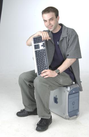 Peter Miljanovic, New Media Studies Student, posing with Apple Computer, Promotional Image
