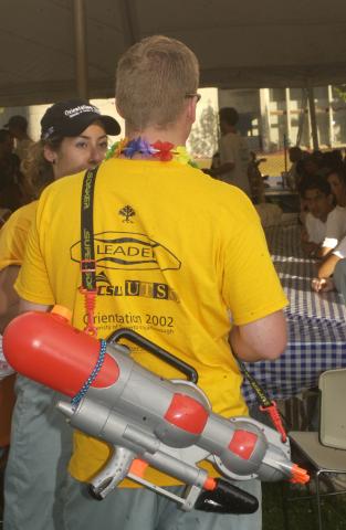 Students in Marquee with Orientation Leader Wearing Water Blaster, Orientation, 2002
