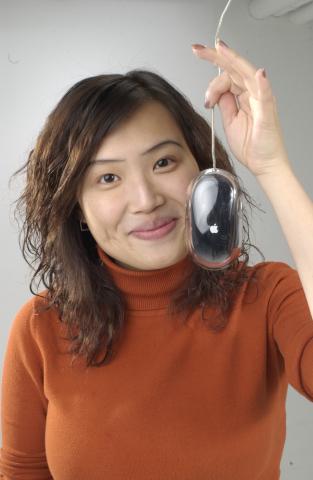 Wynne Leung, New Media Studies, Co-op Student, Holding Mac Mouse, Promotional Photograph