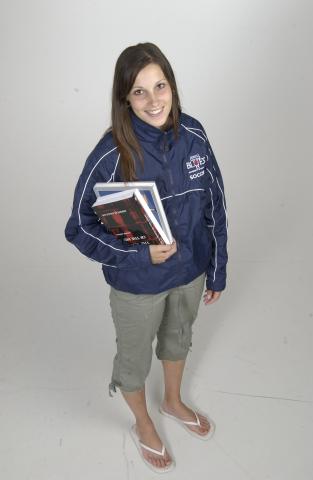 Student Wearing Varsity Blues Jacket, Holding Books, Promotional Image