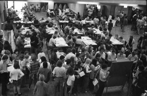 Crowd of Students at Desks With Papers in The Meeting Place