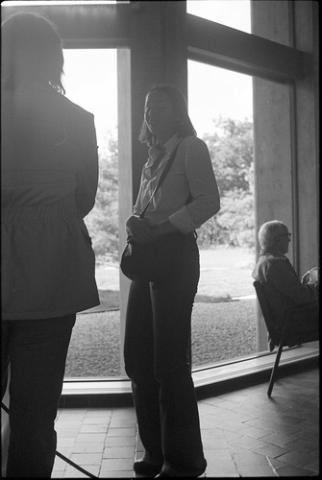 Student Standing and Speaking By Window