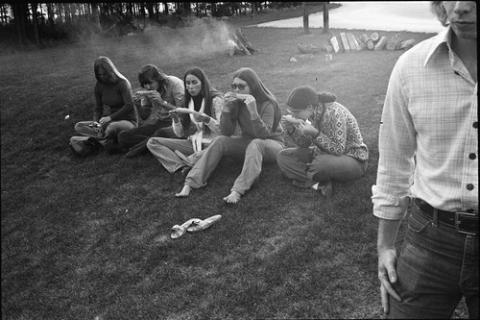Students Sitting on Grass Eating Corn