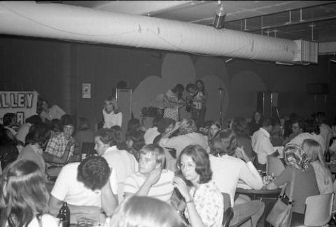 Crowd of Students Seated in College Pub with Band Onstage