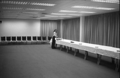 Person Standing by End of Long Table