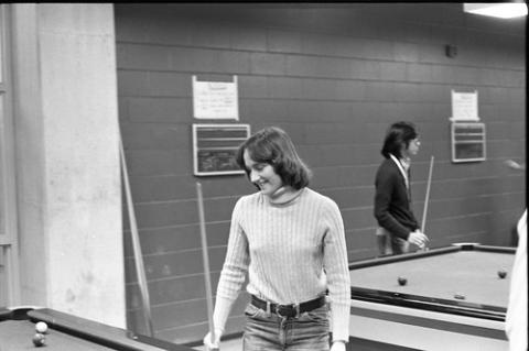 Student Standing by Pool Table with Cue