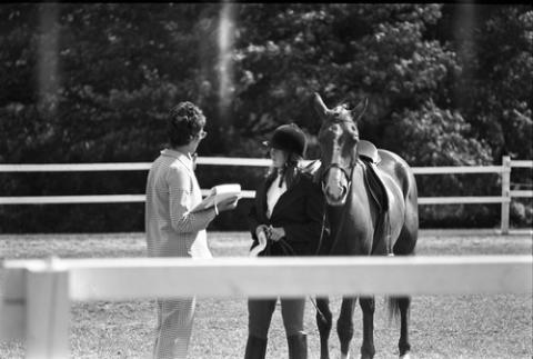 Rider and Horse Show Worker with Papers Speaking