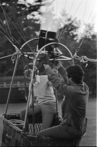 Two People Seated on Edge of Hot Air Balloon
