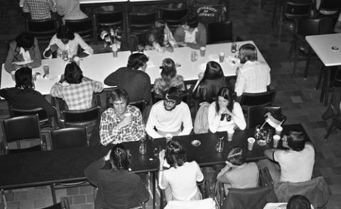 Students Seated at Tables with German Flags in The Meeting Place