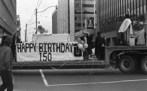 Students on Homecoming Float with Sign Reading 'Happy Birthday 150'