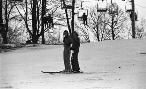 Two Students Standing Below Ski Lift