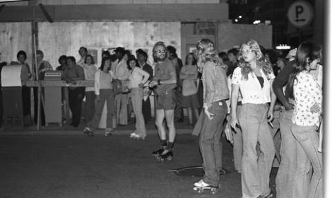 Students in Rollerskates with Crowd on Sidewalk